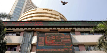 File photo: a bird flies past a screen displaying the sensex results on the facade of bse building in mumbai